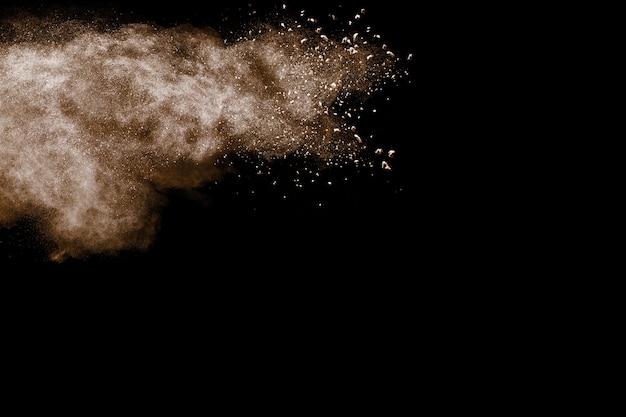Bruine poederexplosie op zwarte achtergrond.