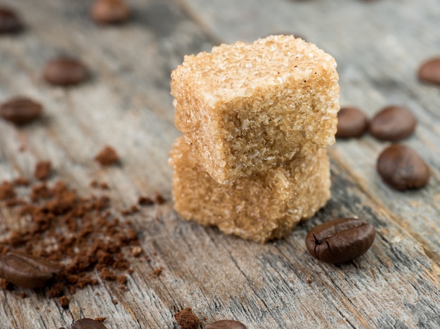 Bruine rietsuiker met koffiebonen op rustieke houten achtergrond.