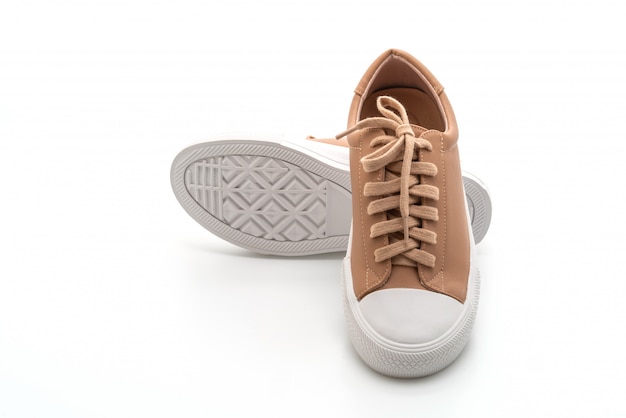 bruine sneakers op witte muur