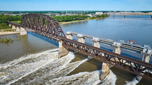 Bruine truss spoorwegbrug over grote dam antenne met verre kust