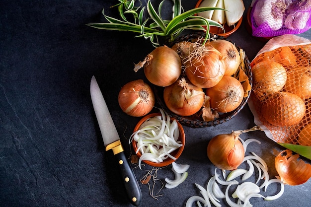 Bruine uien en plakjes op houten snijplank. Gezonde voeding achtergrond.