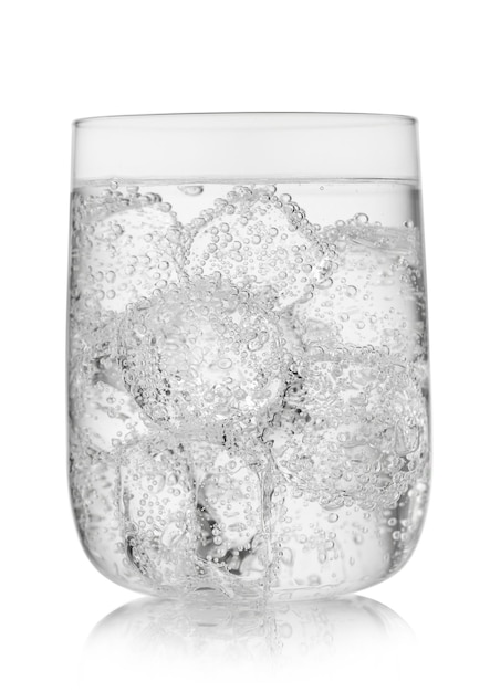 Bruisende mineraalwaterlimonade met ijsblokjes in groot glas op wit