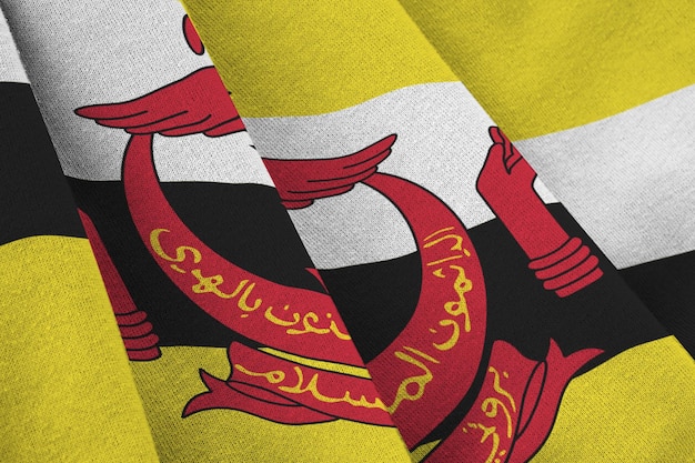 Brunei Darussalam flag with big folds waving close up under the studio light indoors The official symbols and colors in banner