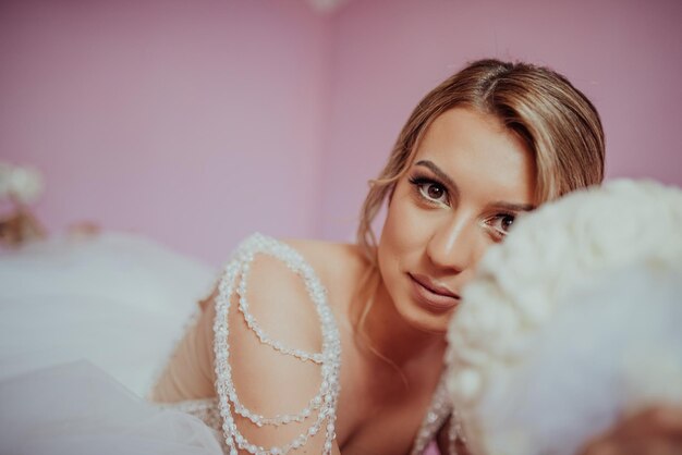 Photo brunet bride posing in pink studio