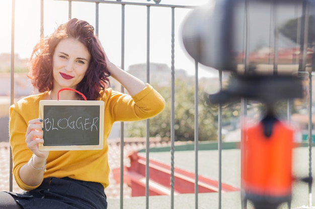 Photo brunette blogger showing blackboard to the camera