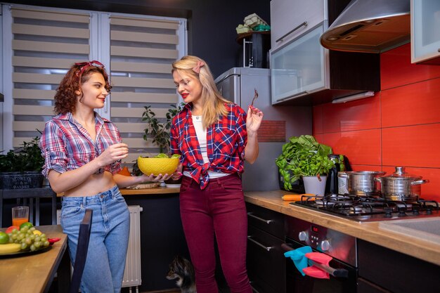 Foto una bruna e una bionda preparano un pasto sano in cucina.