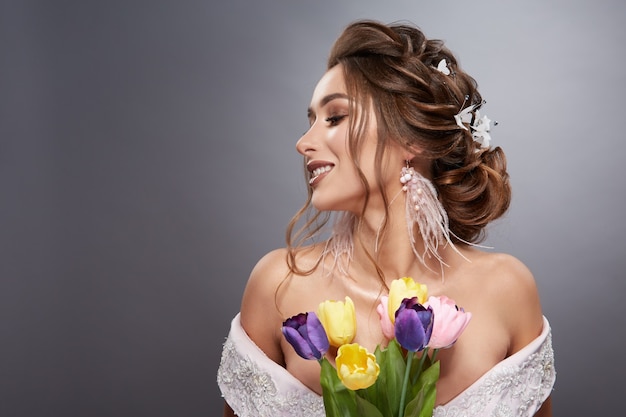 Brunette bride profile with flowered hairstyle and colorful flowers