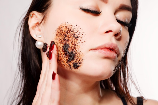 Brunette cleanses the skin with coffee scrub