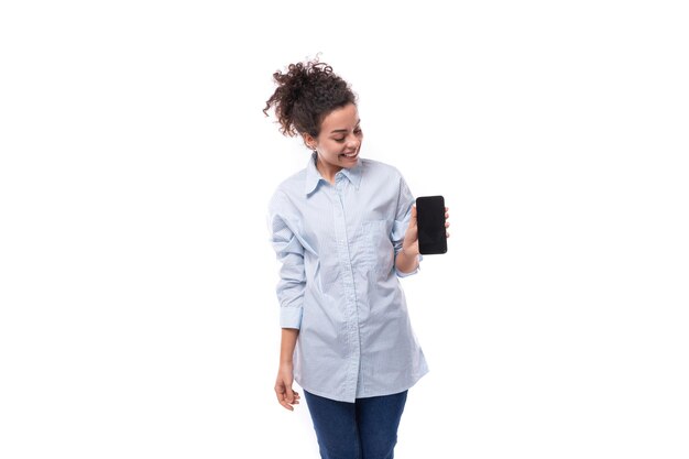 Brunette curly young employee of business company woman shows advertisement on smartphone screen