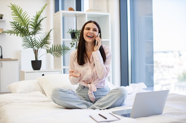 Brunette die apparaten gebruikt en een pauze van het werk geniet voor zakelijke onderhandelingen