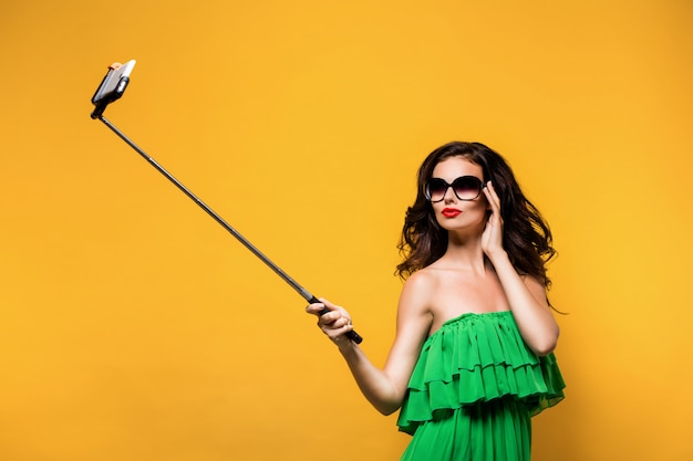 Brunette die selfie in zonnebril maakt