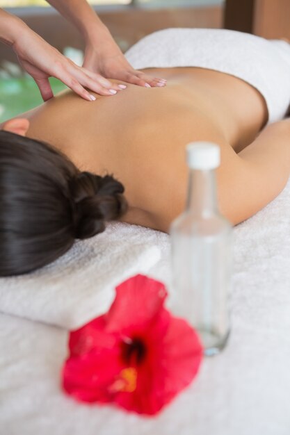 Brunette enjoying a massage lying on towel