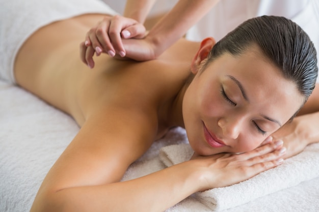 Brunette enjoying a peaceful massage with eyes closed