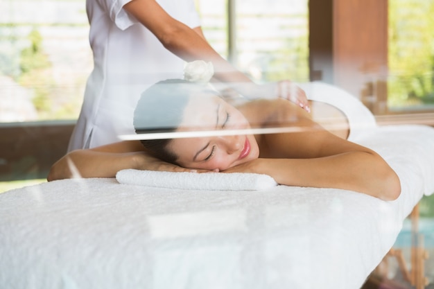 Brunette enjoying a peaceful massage with eyes closed