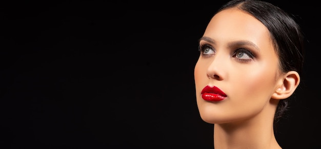 스모키 눈과 빨간 립스틱이 검은 배경에 화장하는 갈색 머리 패션 모델
