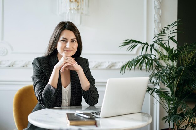 A brunette financier in a business suit Sitting in a comfortable chair and reading