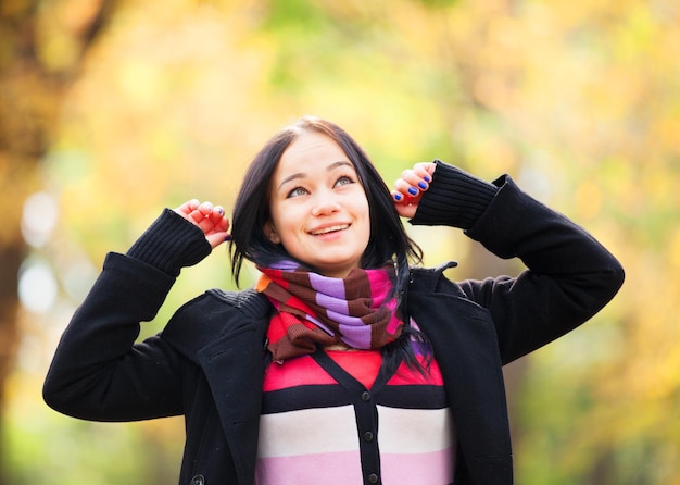 公園の秋の路地でブルネットの女の子