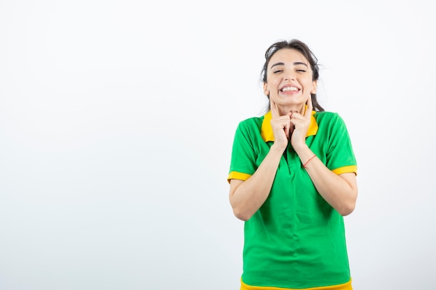 brunette girl in green t-shirt standing and feeling happy. 