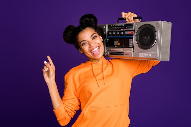 brunette girl in hoody having fun carrying boom box