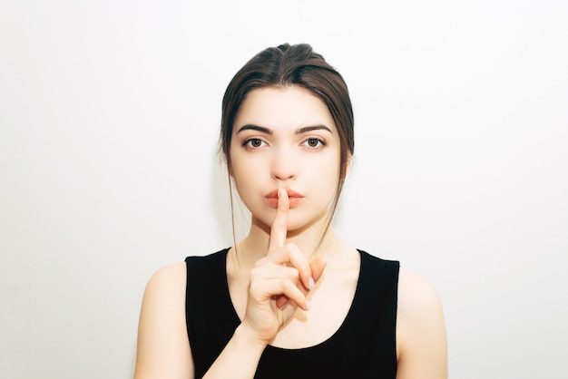 Brunette girl making silence gesture 