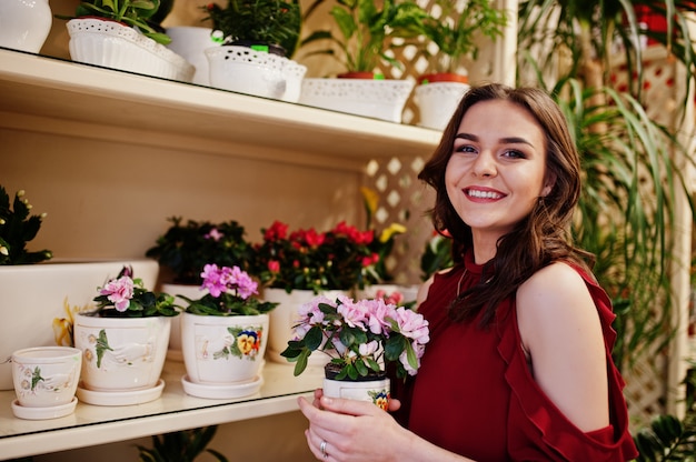 Brunette girl in red buy flowers at flower store.