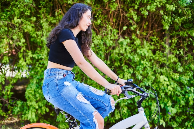 街で自転車に乗るブルネットの少女