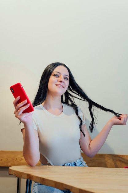 Ragazza bruna che si tocca i capelli in una caffetteria