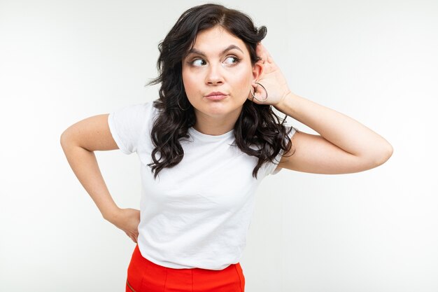 Brunette girl in a white t-shirt eavesdrops on a conversation