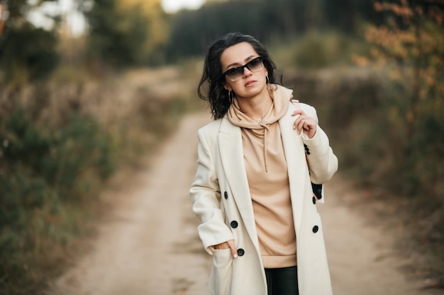 brunette girl with backpack on the forest path