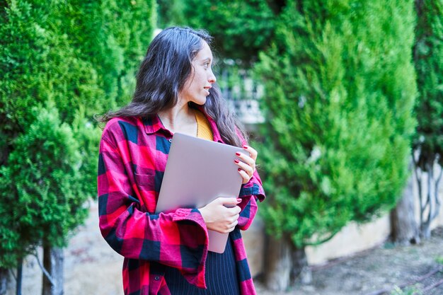 Brunette girl with laptop in the park