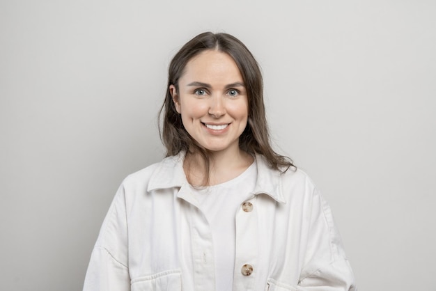 Brunette girl with long hair on a gray background