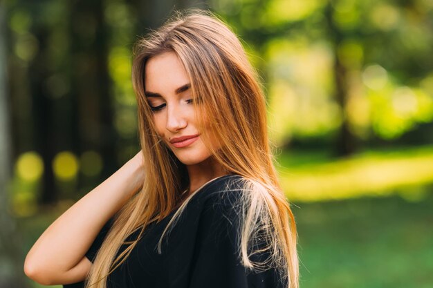 A brunette girl with a makeup looks down and holds her hand in