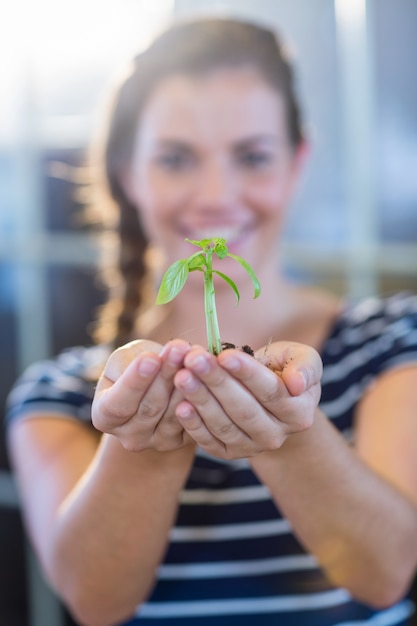 Brunette holding green sprouts