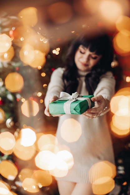 Brunette holding a wrapped gift through bokeh