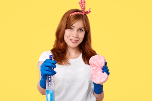 brunette housewife holding cleaning products