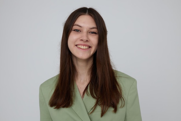 Brunette in groene jas poseren emoties lichte achtergrond