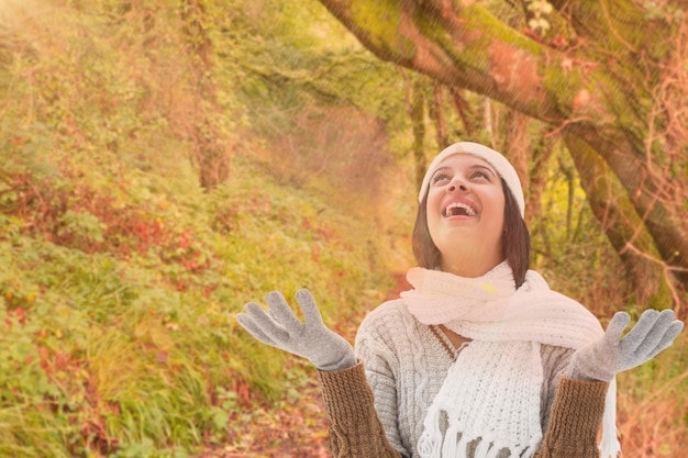 Brunette in warme kleding tegen een rustige herfstscène in het bos