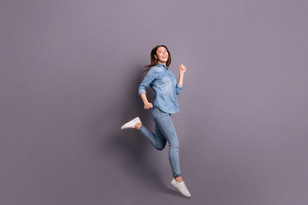 Brunette lady posing against the purple wall