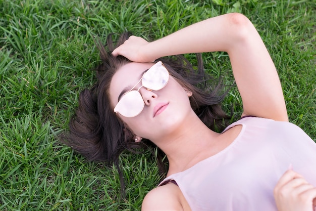 Brunette lady resting outside on grass