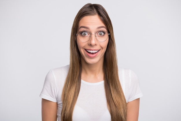 brunette lady with glasses posing against the white wall