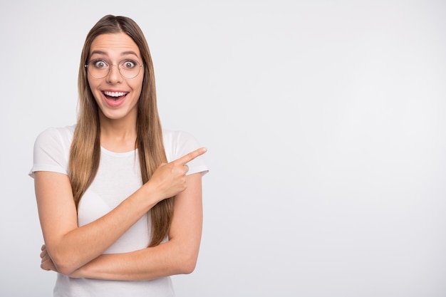 brunette lady with glasses posing against the white wall