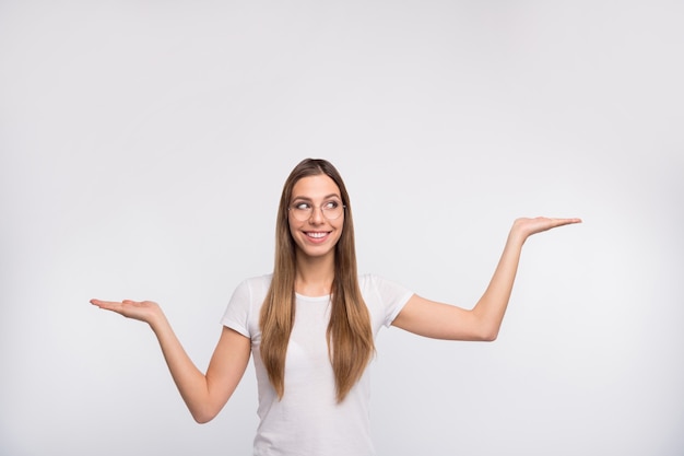 brunette lady with glasses posing against the white wall