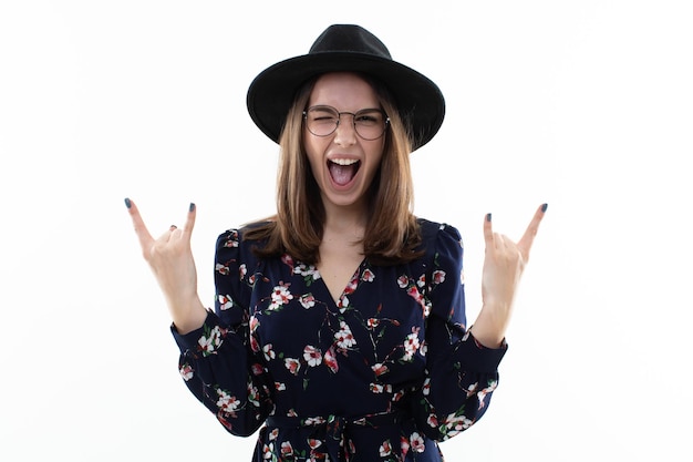 Brunette in a long floral dress with a hat shows a rocker goat