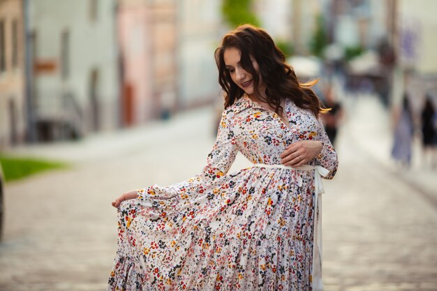 Brunette loopt door de straten van Lviv in een mooie lange jurk