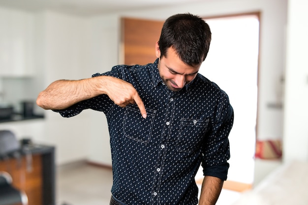 Brunette man pointing down inside house