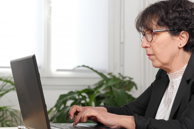 Brunette mature woman using laptop