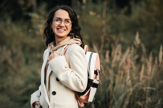 brunette meisje met rugzak op het bospad