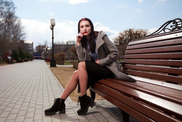 Brunette meisje zittend op een bankje