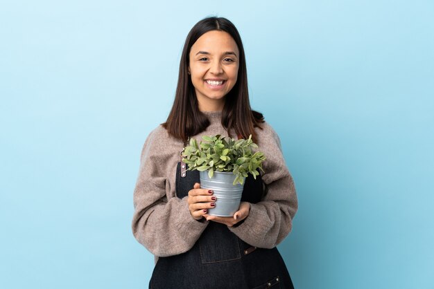 brunette mixed race woman holding a plant applauding