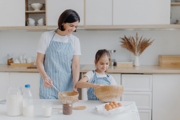 brunette mother and little kid make cookie dough